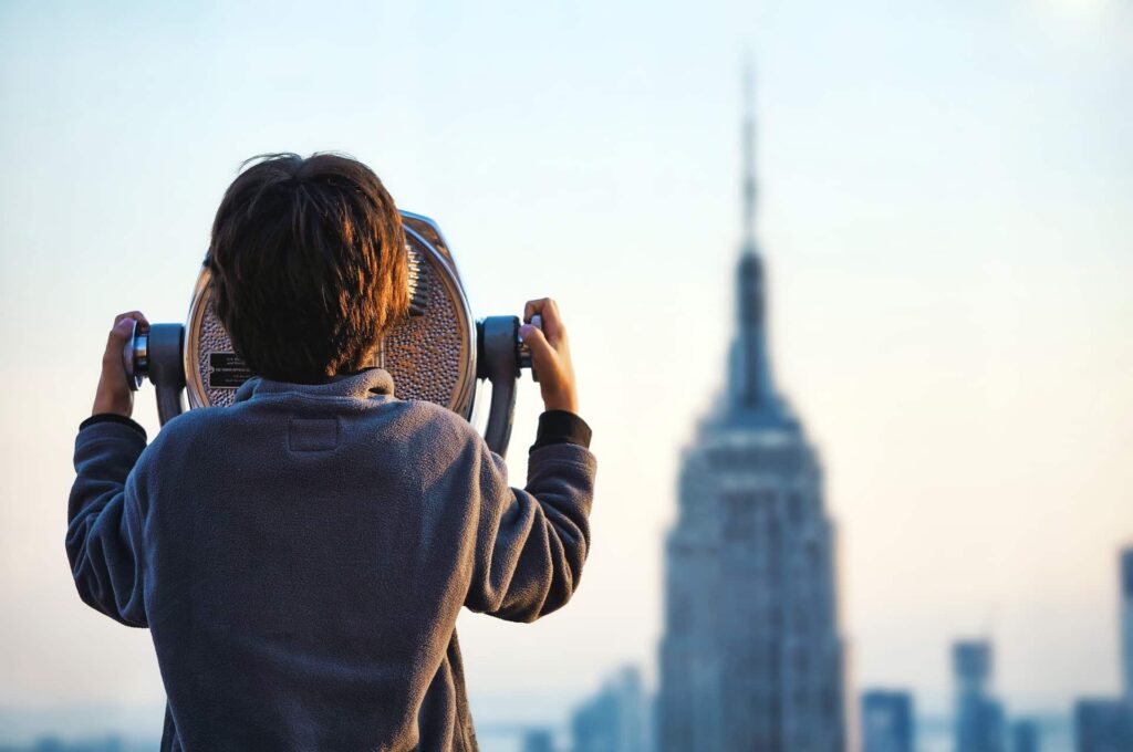 Obserwator - chłopiec obserwujący miasto przez teleskop